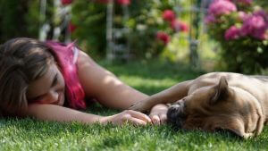 Girl laying with her dog in the garden